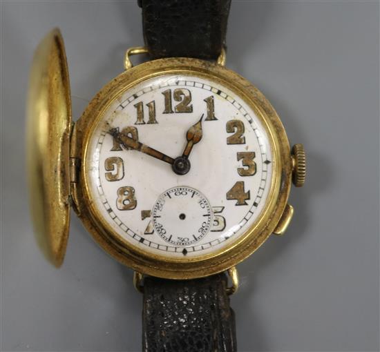 A gentlemans early 20th century 18ct gold half hunter wrist watch.